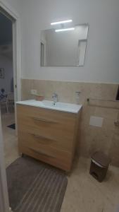 une salle de bain avec un lavabo et un miroir dans l'établissement Appartamento in pieno centro I mori e le dame, à Palerme 35 autres photos