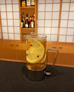 a glass of tea with a lemon on a counter at 泊まれるbarたにかぜ in Tokimata