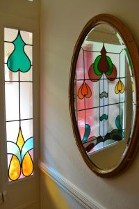 a mirror on a wall with stained glass windows at Knightsrest in Burnham on Sea