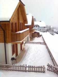a house covered in snow with a fence at Komfortables Ferienhaus in Sankt Margarethen Im Lungau mit Eigener Sauna in Sankt Margarethen im Lungau