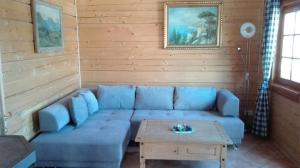 a living room with a blue couch and a table at Komfortables Ferienhaus in Sankt Margarethen Im Lungau mit Eigener Sauna in Sankt Margarethen im Lungau