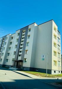 a large building on a street in front of a building at Taikos apartamentas in Mažeikiai