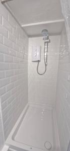 a white bathroom with a shower and a tub at Cottage in Newquay +38 photos