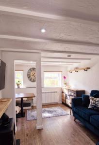 a living room with a couch and a table and a clock at Cottage in Newquay