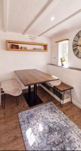 a dining room with a wooden table and a clock at Cottage in Newquay