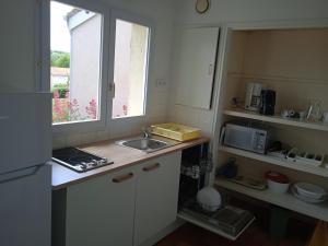 a small kitchen with a sink and a window at Olydea le Lambon - Prailles-la-Couarde in Prailles