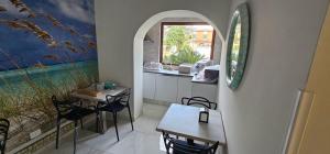 a dining room with two tables and a window at La casa dell'artista in Ardea