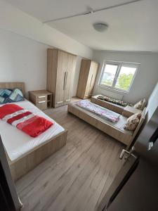 um quarto com duas camas e uma janela em ECO COVER APARTMENTs em Oradea International Airport