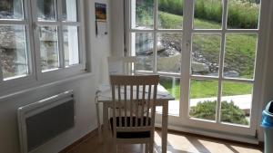 a dining room with a table and chairs and windows at Ferienhaus in Sankt Margarethen Lungau mit Garten in Sankt Margarethen im Lungau