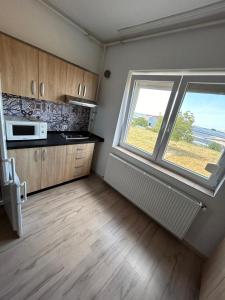 uma cozinha vazia com uma janela e um micro-ondas em ECO COVER APARTMENTs em Oradea International Airport