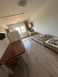 um quarto com duas camas e uma secretária em ECO COVER APARTMENTs em Oradea International Airport mais 4 fotografias