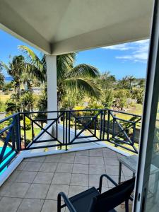a balcony with a view of the beach and palm trees at La Caz in Bouchon