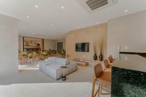 a living room with a white couch and chairs at My Allure Moema - Com café da manhã e Recepção 24 horas in São Paulo