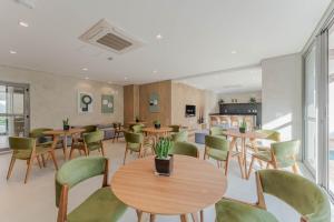 a restaurant with wooden tables and green chairs at My Allure Moema - Com café da manhã e Recepção 24 horas in São Paulo