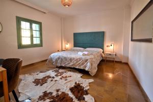 a bedroom with a bed with a blue headboard at Villa Arte de Aguilas in El Palo +21 photos