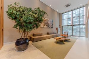 圣保罗Apartamentos Studio Allure Moema - Com café da manhã opcional, Recepção e Valet 24 horas的一个大锅里树的客厅 更多37张照片