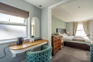 a bedroom with a bed and a desk with two chairs at Penhelig Arms in Aberdyfi