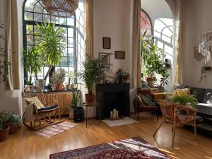 a living room filled with lots of potted plants at Studio Włókno - słoneczny loft u Scheiblera in Łódź