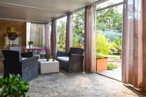 a patio with chairs and a table and glass doors at Scappo in Umbria, Eva in Fornole