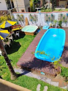 a pool in a backyard with a table and an umbrella at Pousada Beach Eco House Floripa Com Ar Condicionado in Florianópolis
