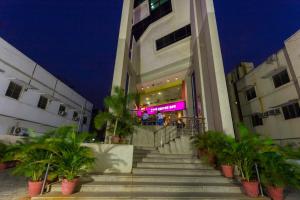 a building with stairs and palm trees in front of it at Ginger Chennai - Vadapalani in Chennai