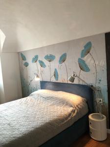 a bedroom with a bed with blue feathers on the wall at Gusterhouse Castellazzo in Ivrea