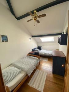a room with two beds and a ceiling fan at Maison à la campagne avec PISCINE et JACUZZI in Buanes
