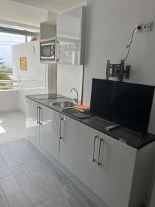 a kitchen with a counter with a sink and a microwave at Tobago215 in Puerto Rico de Gran Canaria +12 photos