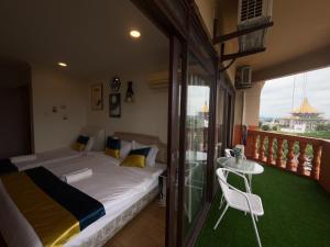 a bedroom with a bed and a table and a balcony at Level 12 Riverbank suites 2BR RiverView in Kuching +18 photos