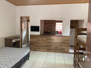 ein Schlafzimmer mit einem Bett und einem Fernseher in einem Zimmer in der Unterkunft Casa Temporada Damata in Ubatuba