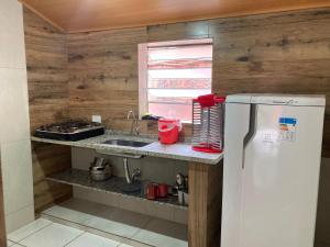 eine Küche mit Spüle und Kühlschrank in der Unterkunft Casa Temporada Damata in Ubatuba