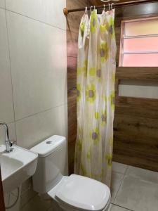 ein Badezimmer mit Toilette und Duschvorhang in der Unterkunft Casa Temporada Damata in Ubatuba + 14 Fotos