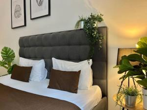 a bed with white pillows and plants on it at Beautiful New Town Apartment in Prague