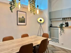 a dining room with a wooden table and a kitchen at Beautiful New Town Apartment in Prague +12 photos