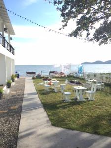 a row of white tables and chairs near the water at Kodtalay Resort in Chao Lao Beach