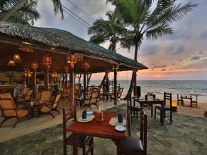 a restaurant on the beach with tables and chairs at Thejan Beach Cabanas in Bentota