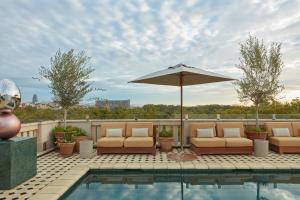 Eine Terrasse mit Stühlen und einem Sonnenschirm neben einem Pool in der Unterkunft Miiro Borneta in Barcelona