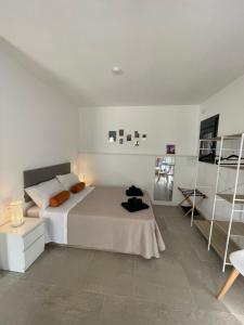 biała sypialnia z łóżkiem i półką w obiekcie Bella Boutique Apartments w mieście Cómpeta +44 zdjęcia
