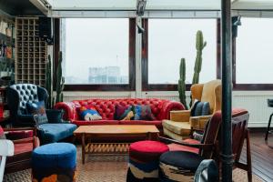 a living room with a red couch and chairs at The Click Clack Hotel Bogotá in Bogotá