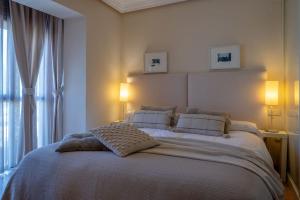 ein Schlafzimmer mit einem Bett mit zwei Lampen und einem Fenster in der Unterkunft Casa Cortijo del Aire, Granada in Albolote + 45 Fotos