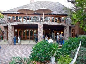 a building with people standing outside of it with umbrellas at Shelanti Game Reserve in Marken