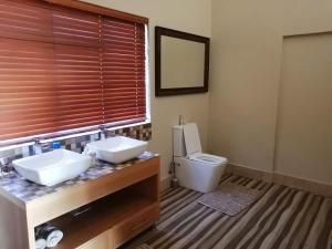 a bathroom with two sinks and a toilet at Shelanti Game Reserve in Marken +17 photos