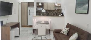a living room with a couch and a table and a kitchen at Casa & Jardim Riviera in Riviera de São Lourenço