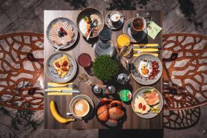 a wooden table with breakfast foods and drinks on it at Villa Sonnenhof Boutique-Hotel in Bad Reichenhall