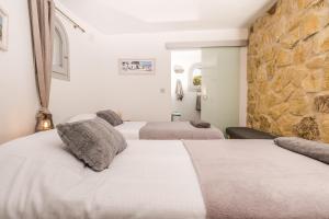 1 Schlafzimmer mit 2 Betten und einer Steinmauer in der Unterkunft Casa au Lilas Rosa in Benissa + 41 Fotos