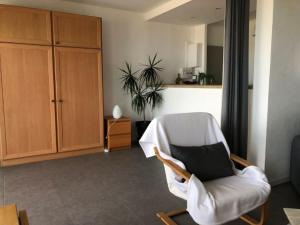 ein Wohnzimmer mit einem weißen Stuhl und einem schwarzen Kissen in der Unterkunft Anglet sables d'or - vue océan in Anglet