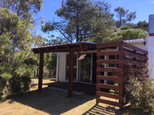 a small house with a wooden fence in front of it at Monoambiente en Valizas in Barra de Valizas +13 photos