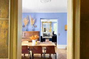 a dining room with blue walls and a table and chairs at Maison Stella Cadente, Maison d'hôtes Artistique et Jardin à Provins in Provins