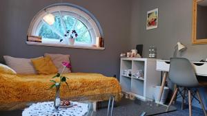 a bedroom with a bed and a window and a desk at Pod Małą Sową in Walim