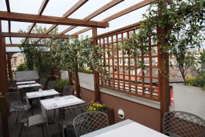 patio ze stołami, krzesłami i drzewami w obiekcie Hotel Metrò w Mediolanie